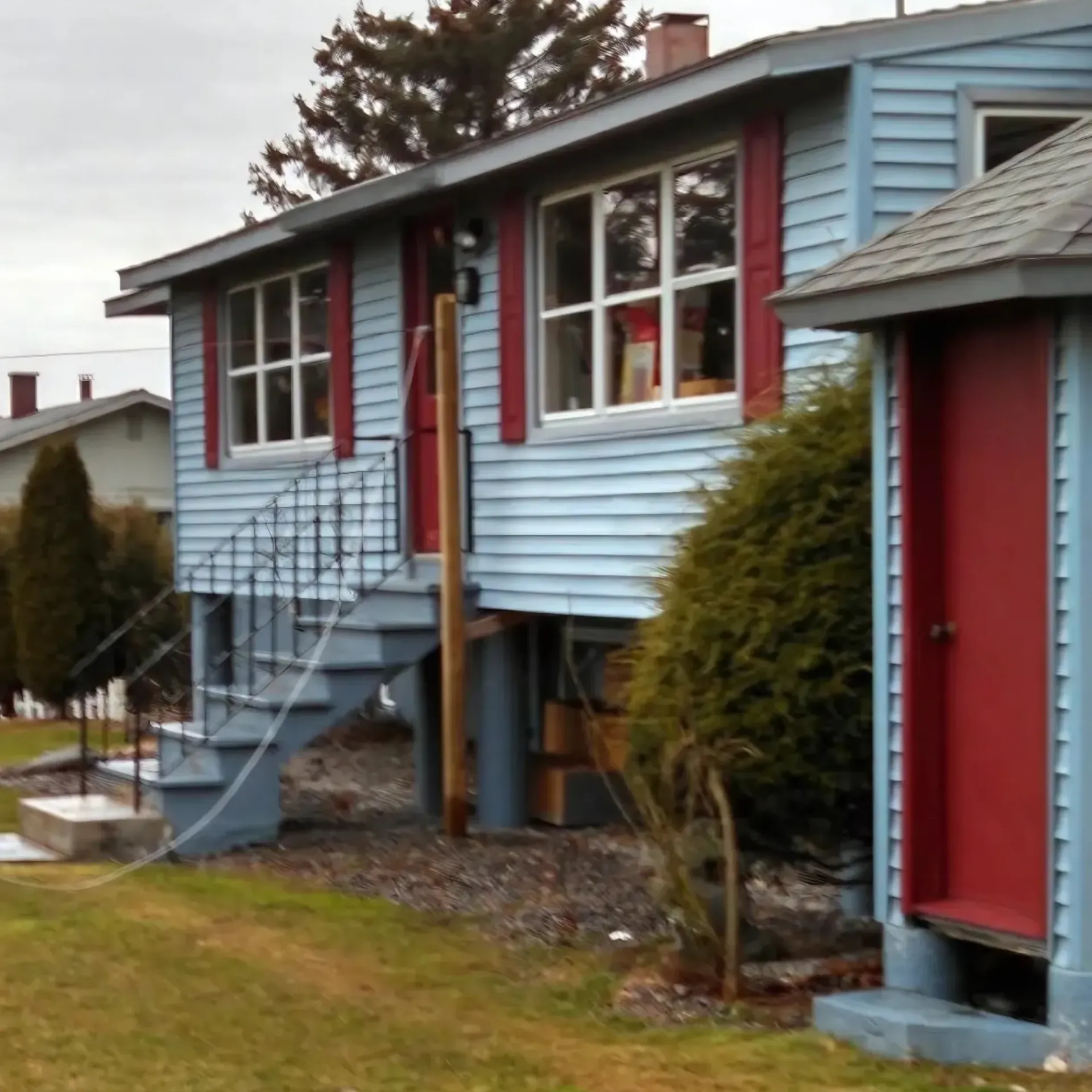 CK Maintenance LLC - A blue house with a red door and stairs