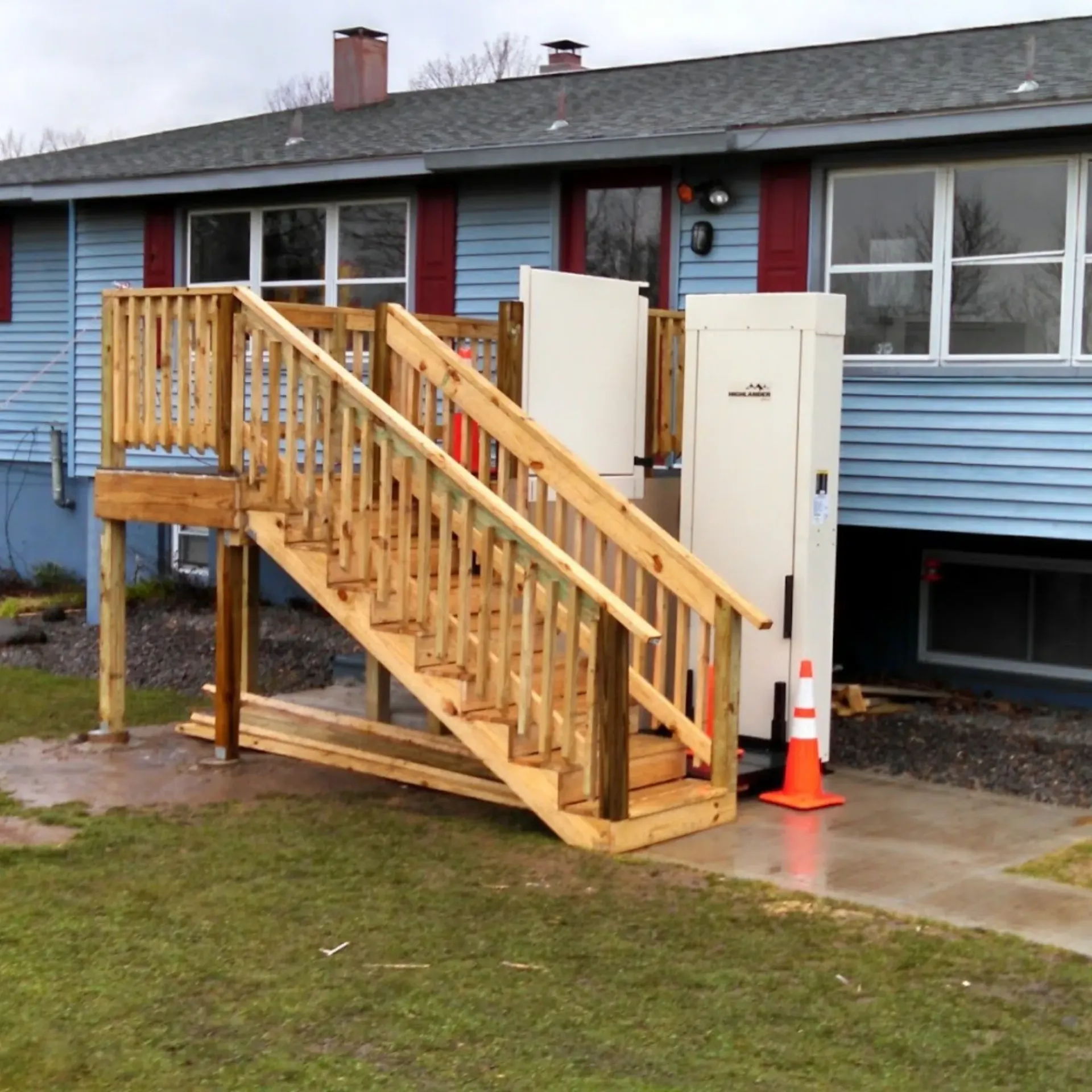 CK Maintenance LLC - A blue house with a wooden deck and stairs