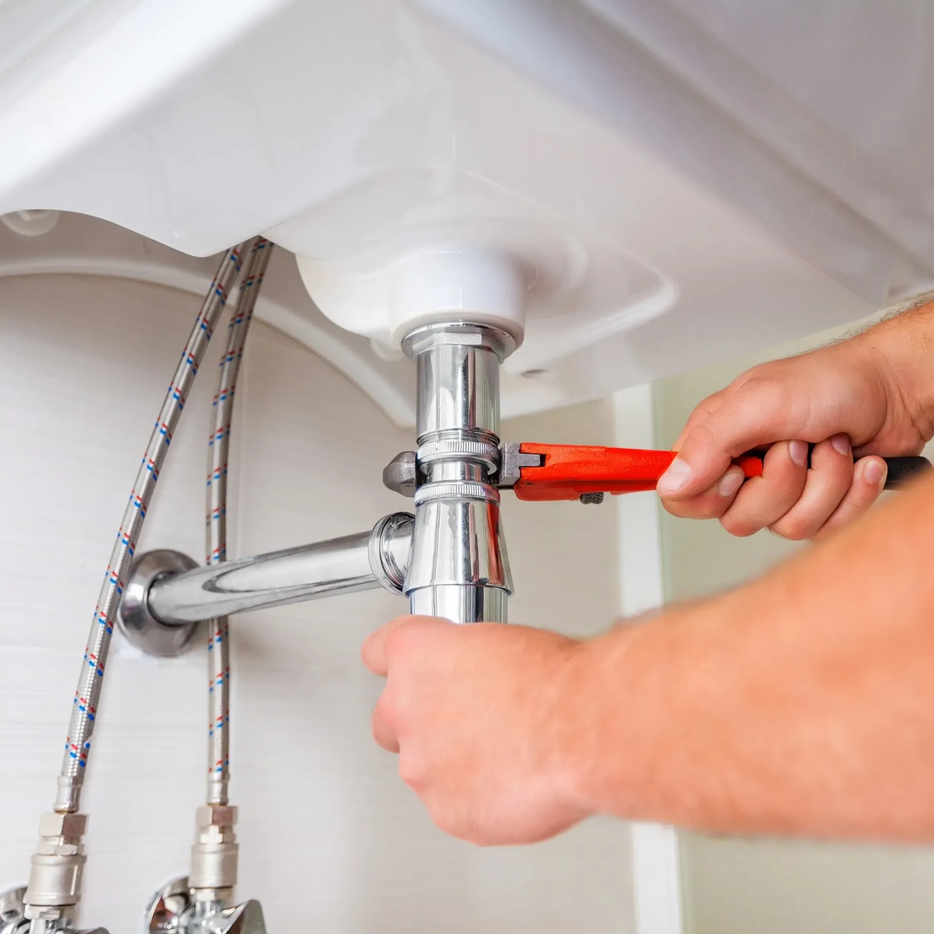 CK Maintenance -  A man is fixing a sink with a wrench.