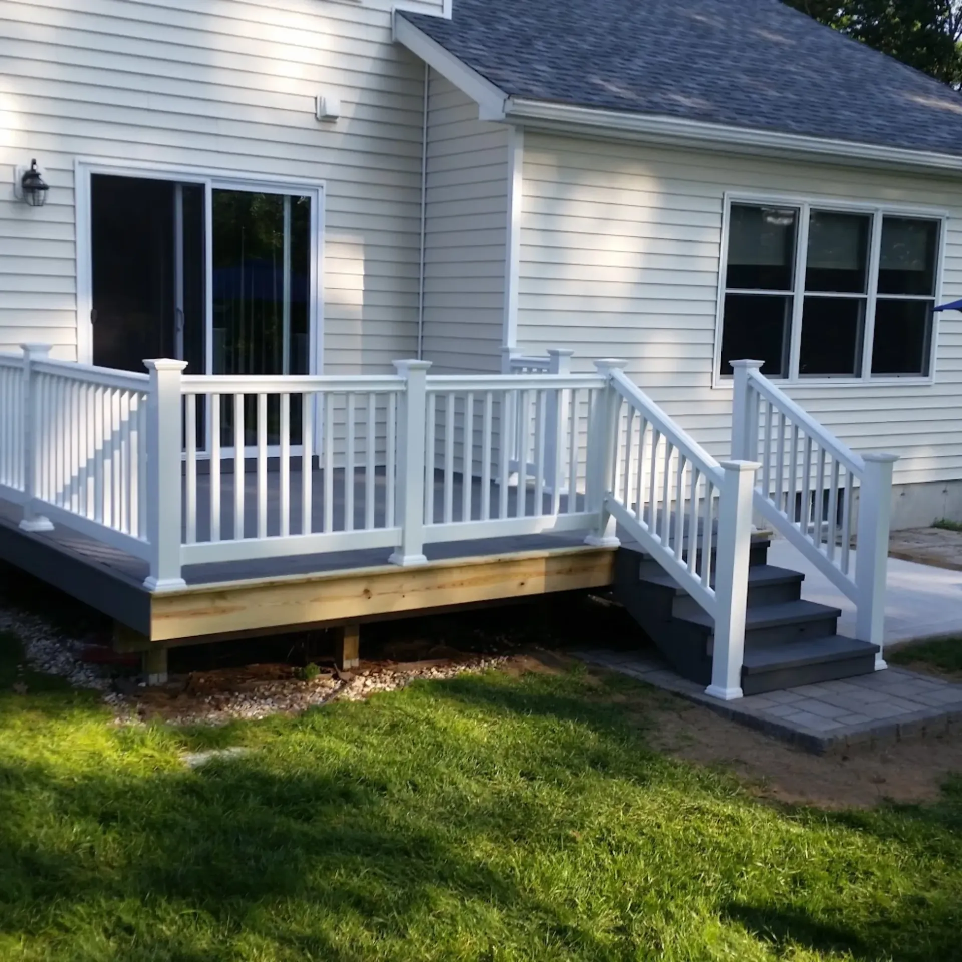 CK Maintenance LLC - A white house with a white deck and stairs