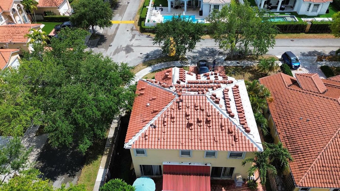 An aerial view of a house with a tiled roof in a residential area.