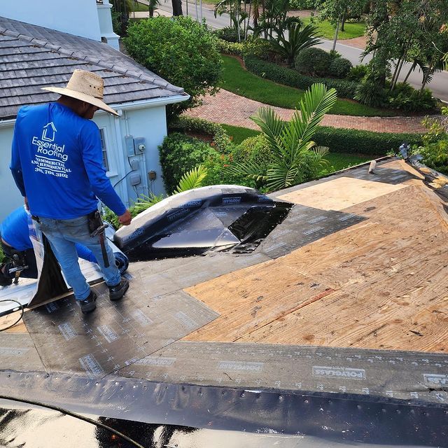 Two men are working on the roof of a house.