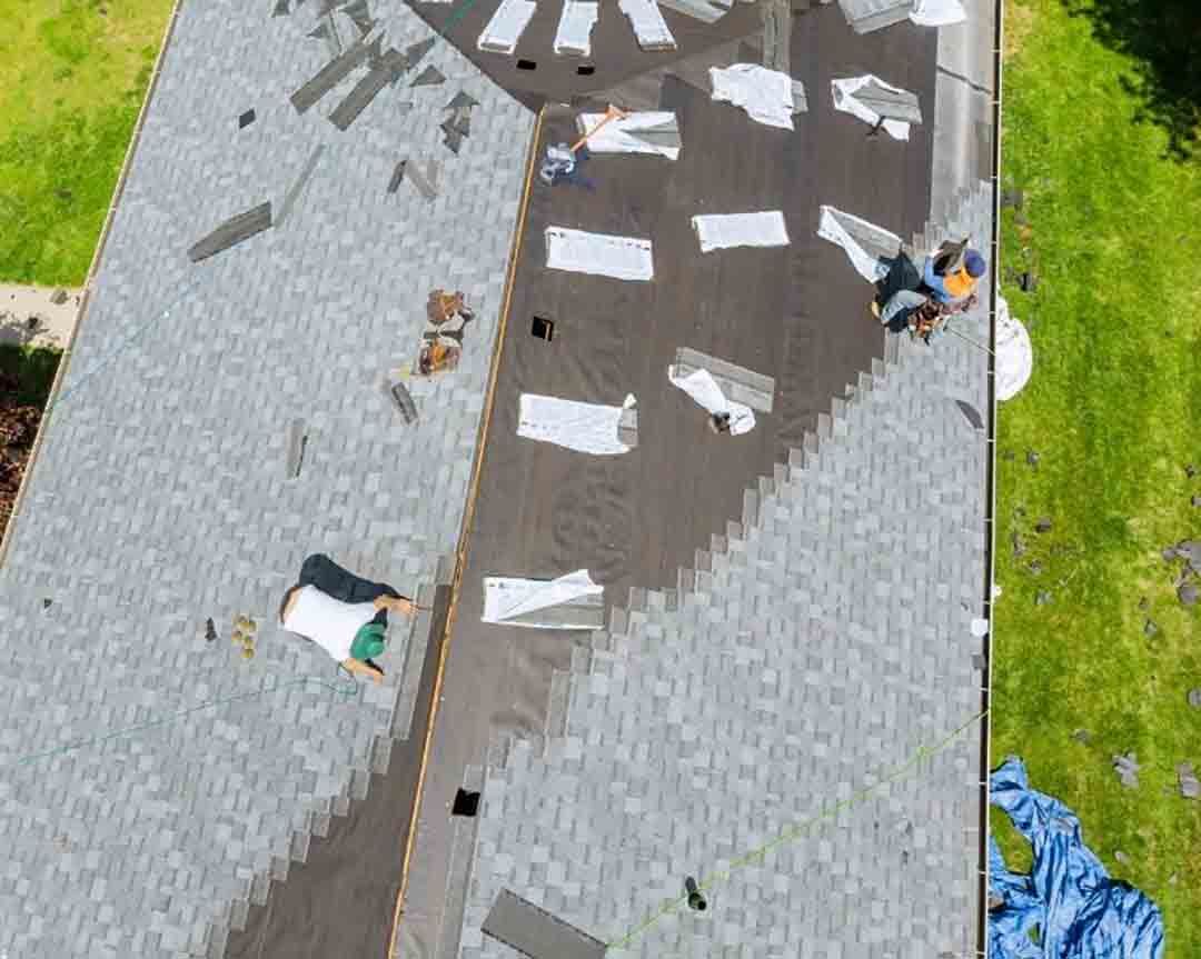 An aerial view of a roof being repaired by a roofer.