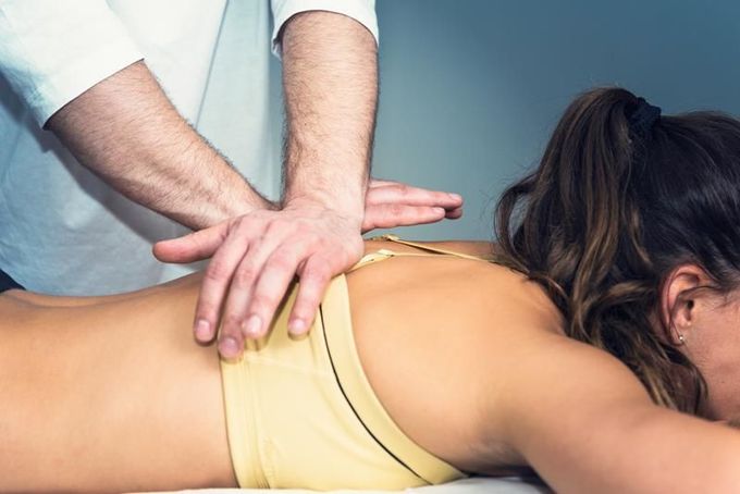 Person receiving back adjustment from a healthcare provider.