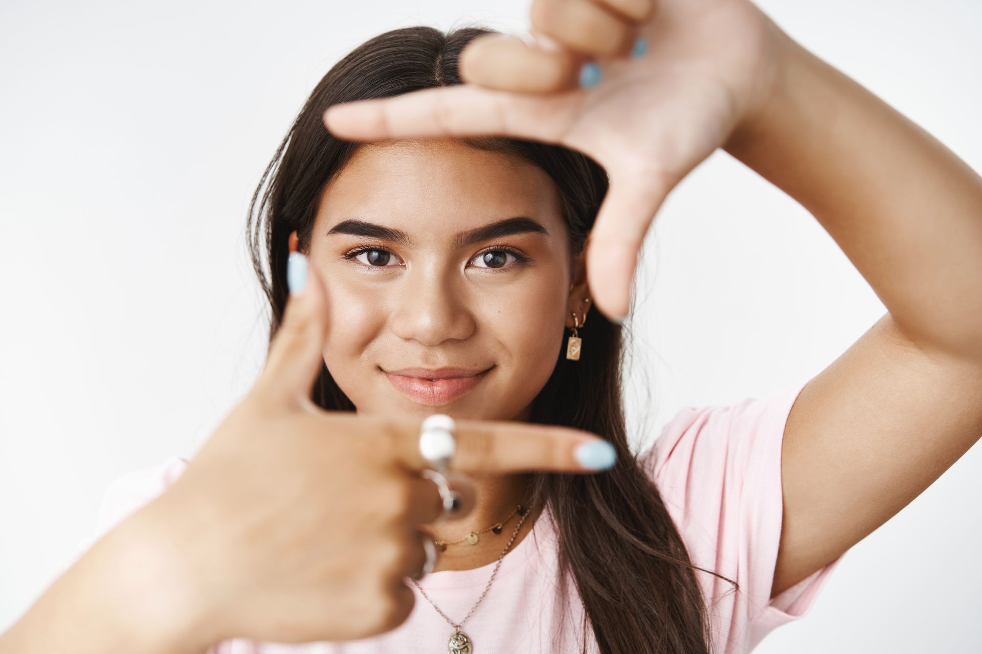 A young woman is making a frame with her hands.