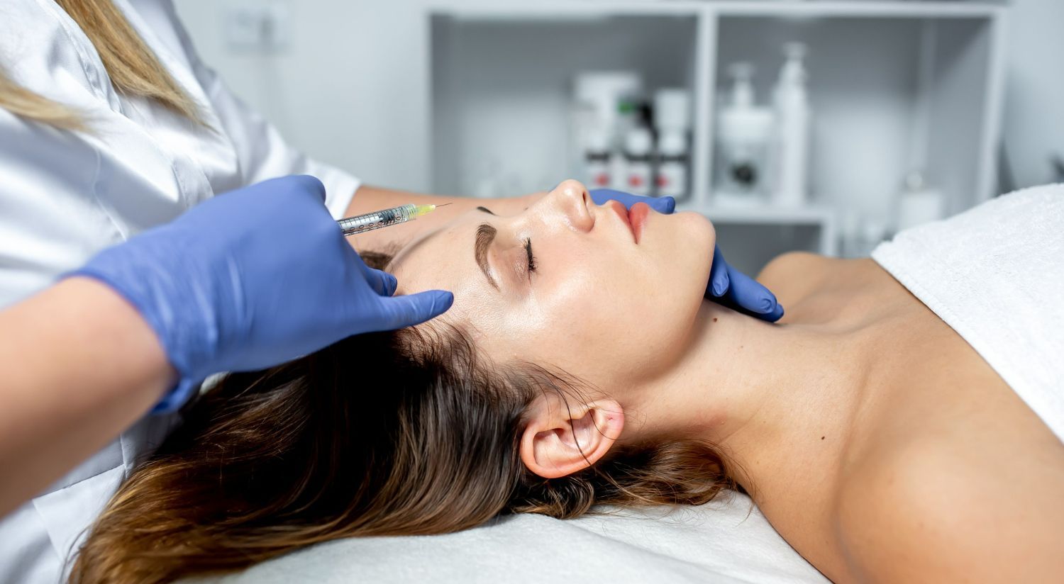 A woman is getting a facial treatment at a beauty salon.