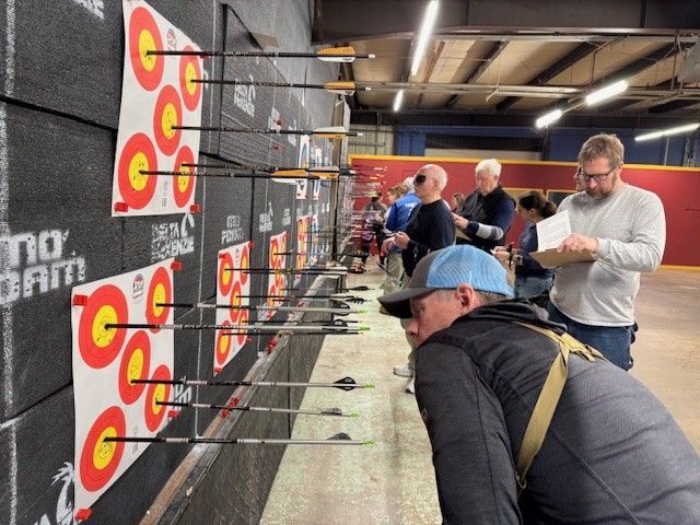 rear view of woman aiming at archery target 
