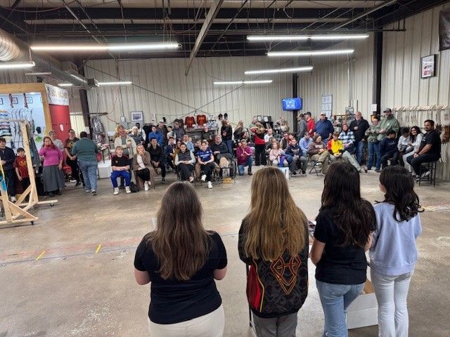 Close-up of a person aiming a red bow. 
