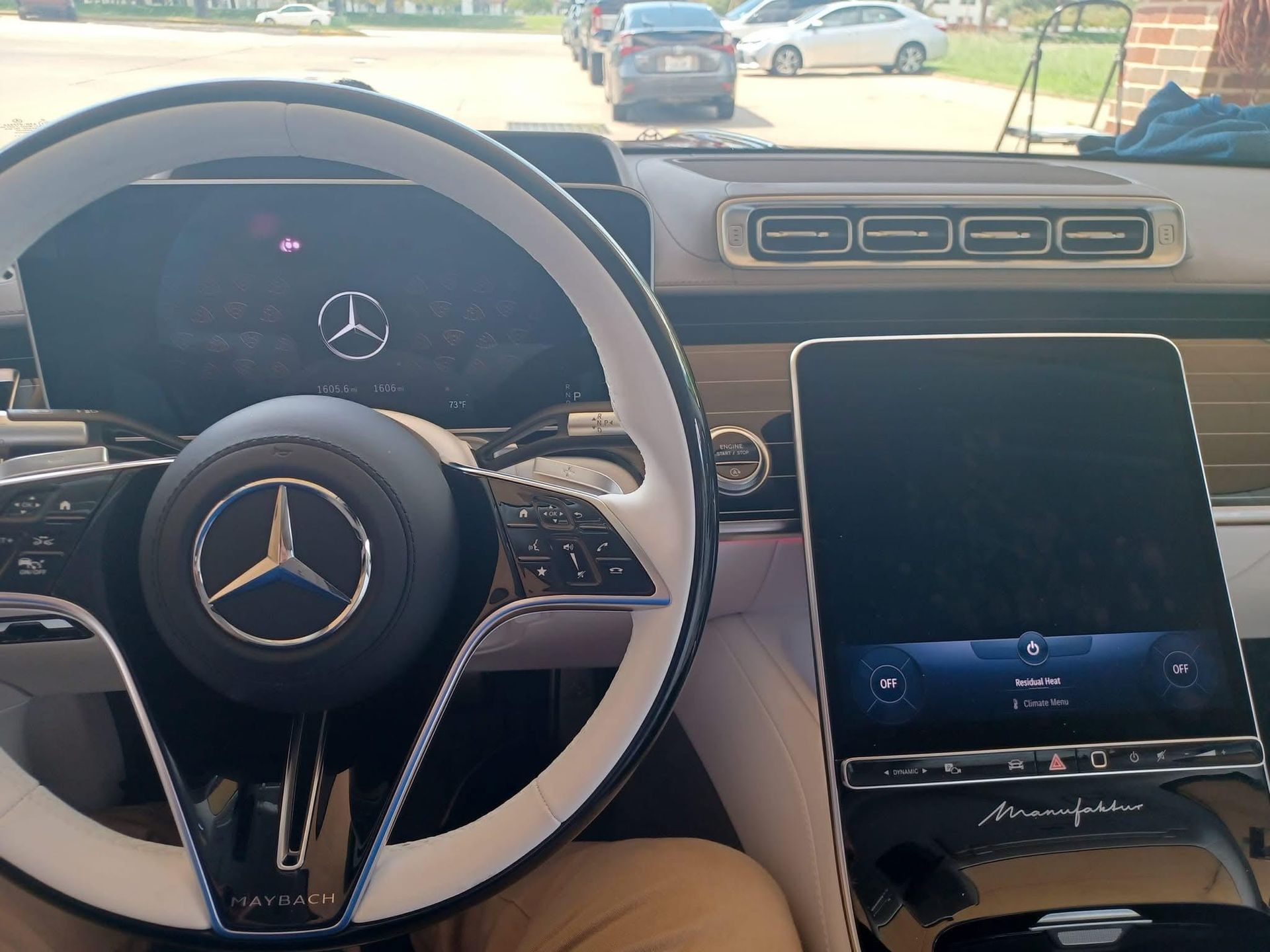 Interior view of a luxury Mercedes-Benz car showing the steering wheel, dashboard, and a large touchscreen display.