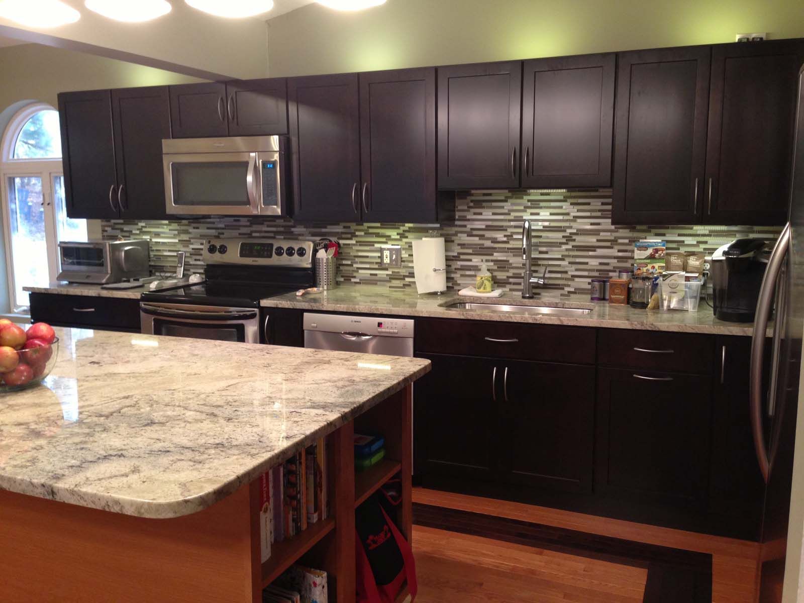 Kitchen with dark brown cabinets, stainless steel appliances, and granite countertops.