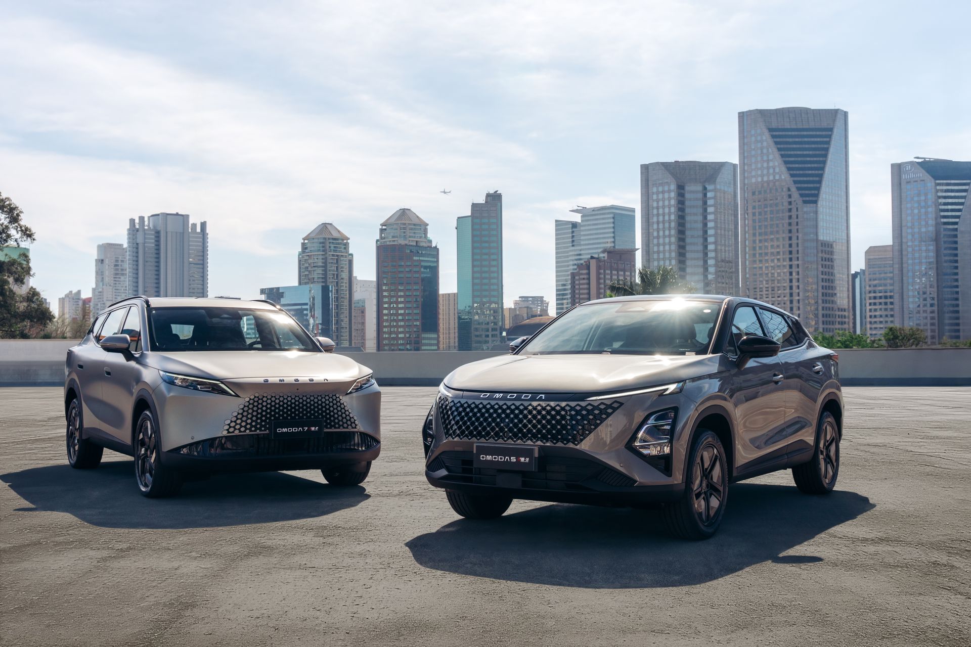 Três carros elétricos em um estúdio escuro com linhas de néon vermelhas. As portas do carro do meio estão abertas.