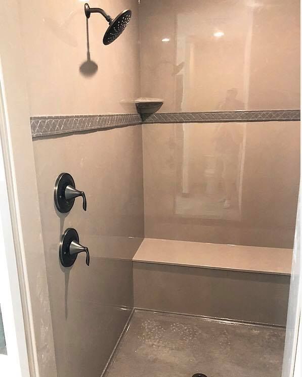 There is a shower with a bench and a shower head.