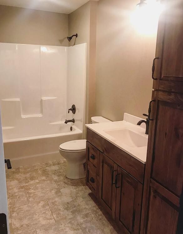 A bathroom with a toilet , sink , bathtub and shower.