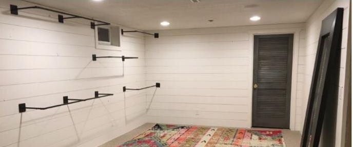 A room with white walls and a rug on the floor.
