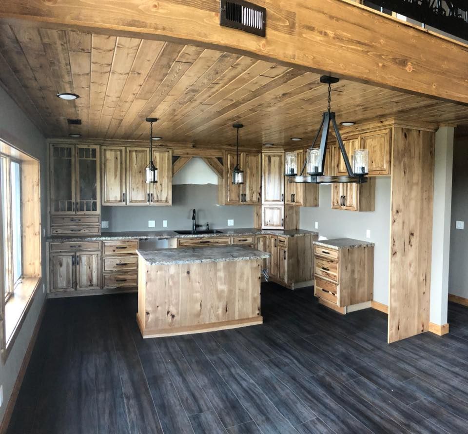 A kitchen with wooden cabinets and a large island