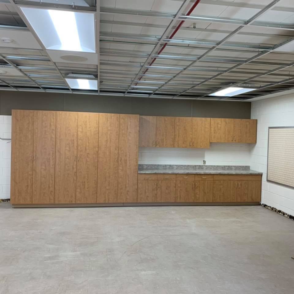 An empty room with wooden cabinets and a white board
