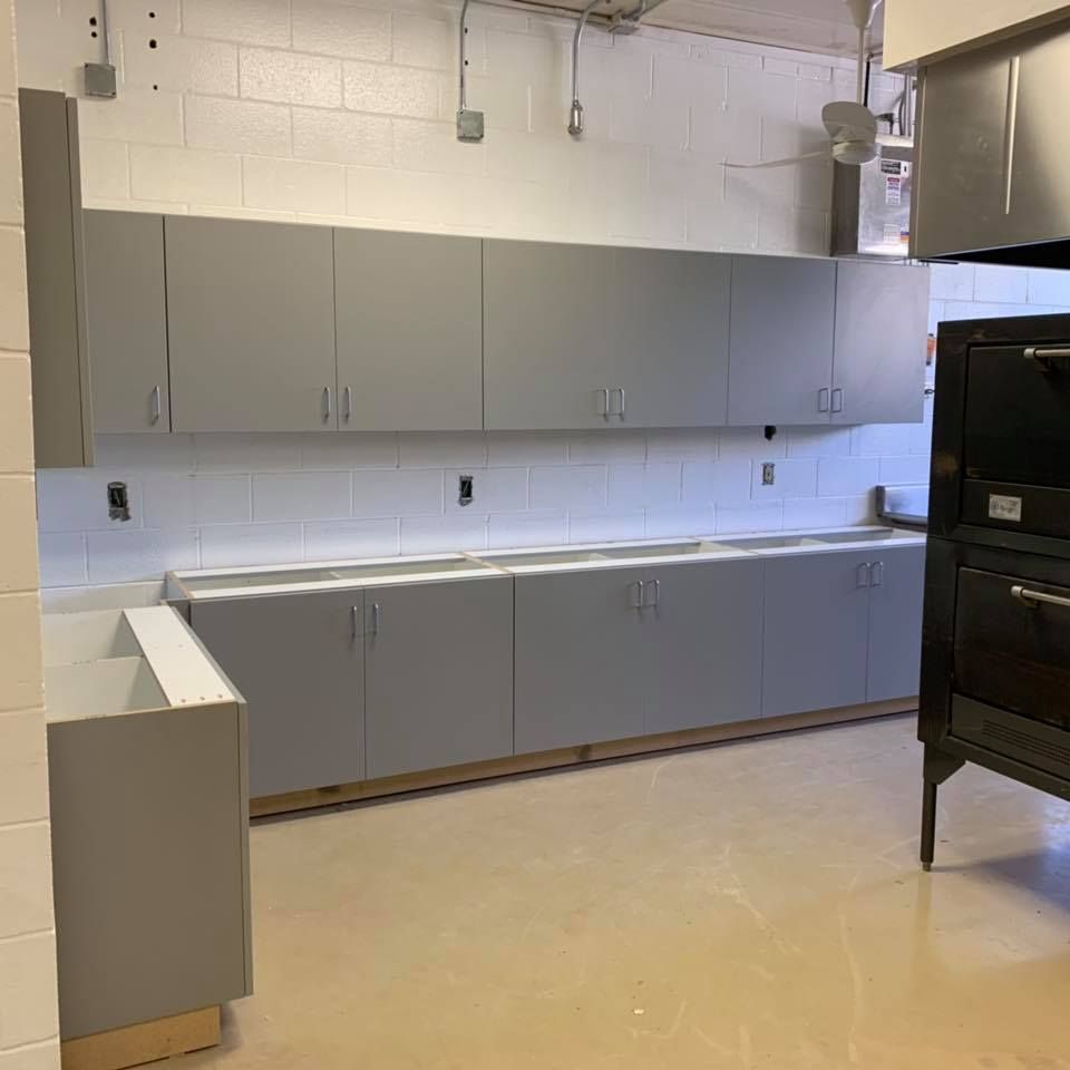 A kitchen with gray cabinets and a black oven
