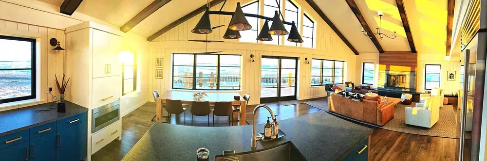 A kitchen with a sink , dining table , and living room.