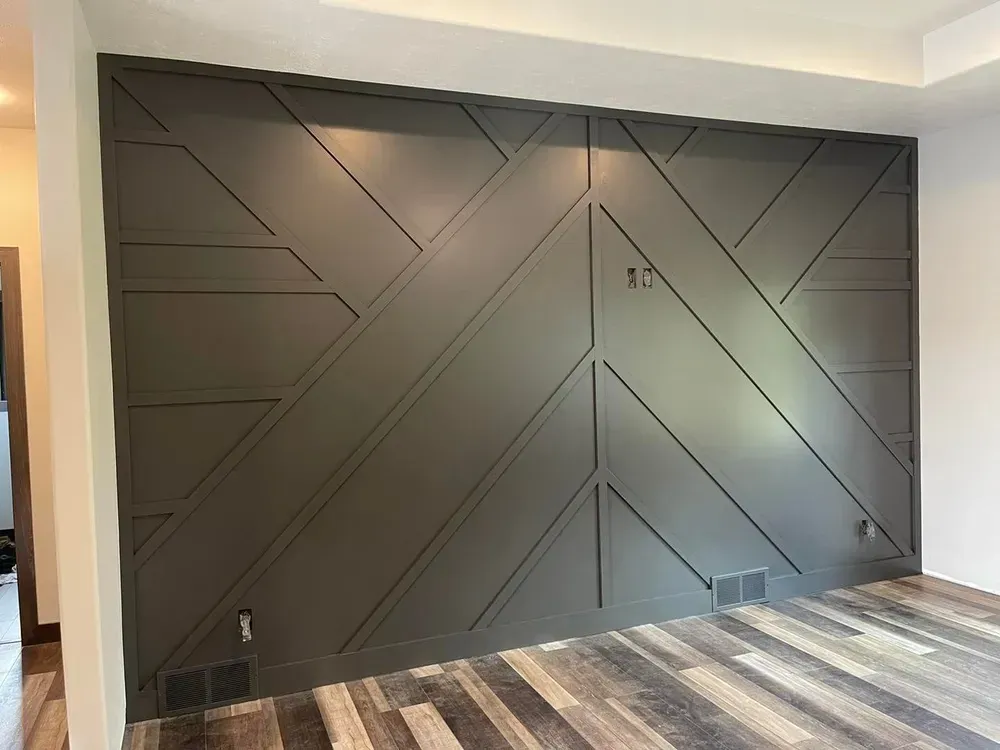 A living room with a gray wall and a wooden floor.