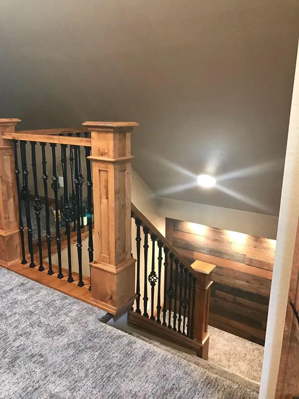 A wooden staircase with a metal railing in a house.