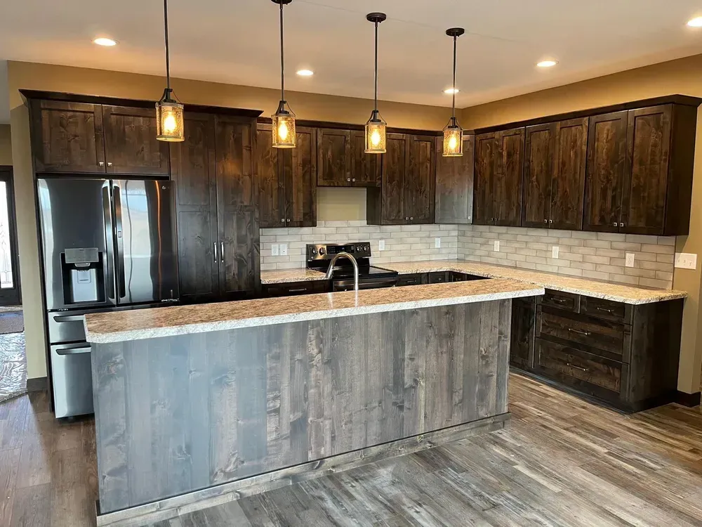 A kitchen with wooden cabinets , granite counter tops , stainless steel appliances and a large island.