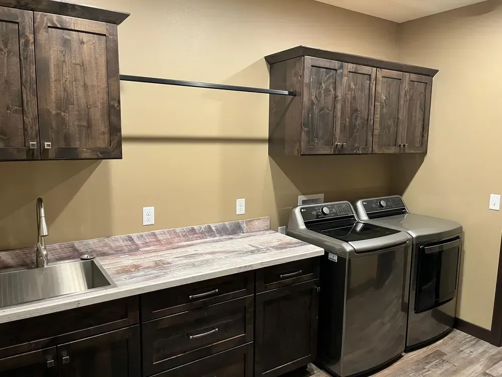 A laundry room with a washer and dryer , sink , and cabinets.