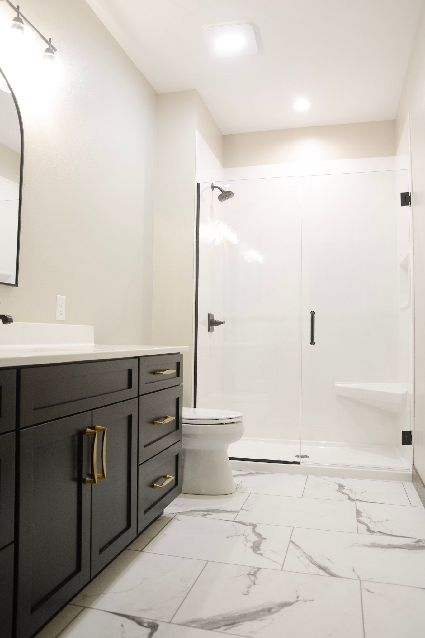 A bathroom with a sink , mirror and wooden cabinets.