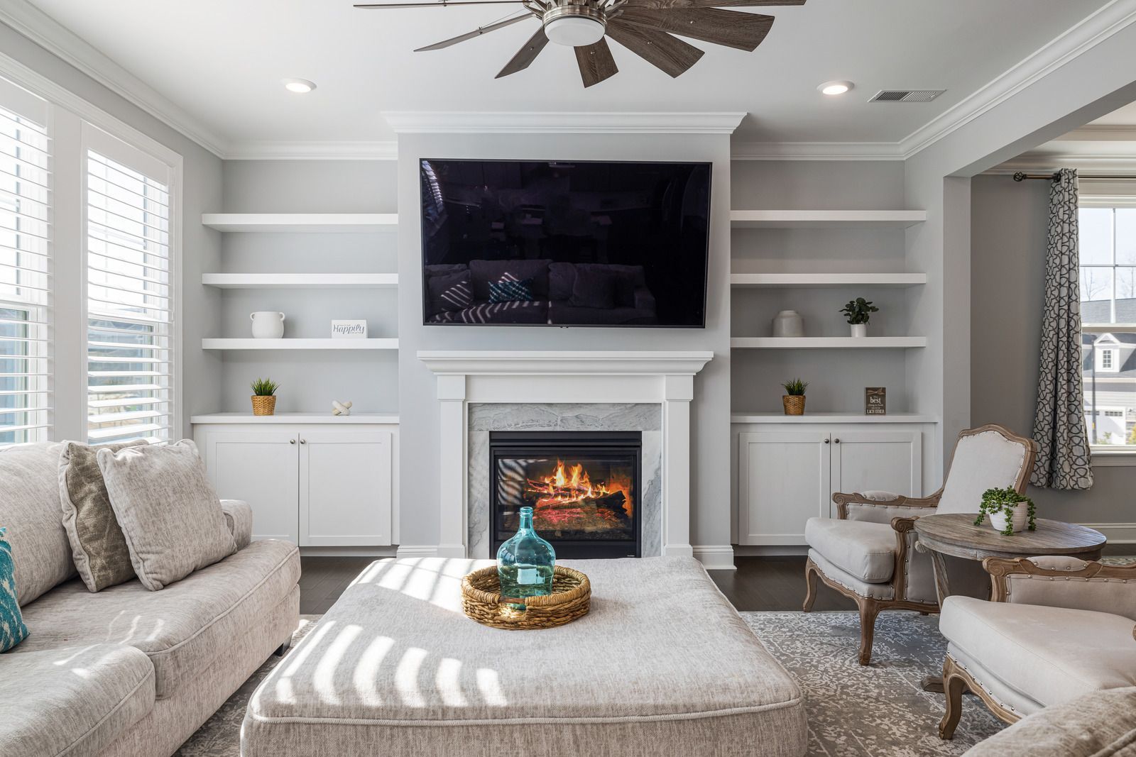 A living room with a fireplace and a flat screen tv on the wall.