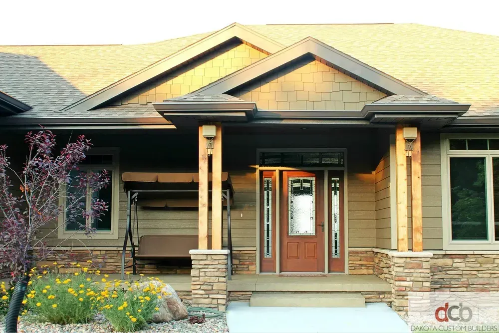 The front of a house with a porch and a swing.