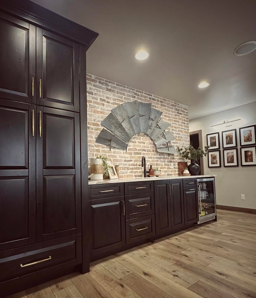 Modern kitchen with dark wood cabinets, brick backsplash, and decorative fan wall accent