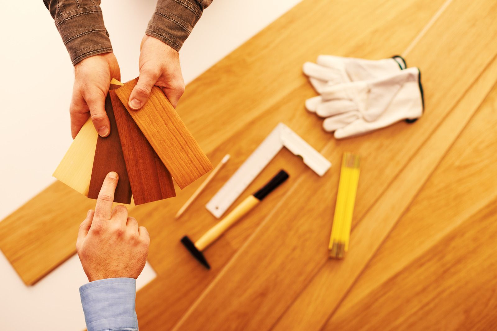 A person is holding a piece of wood and pointing at it