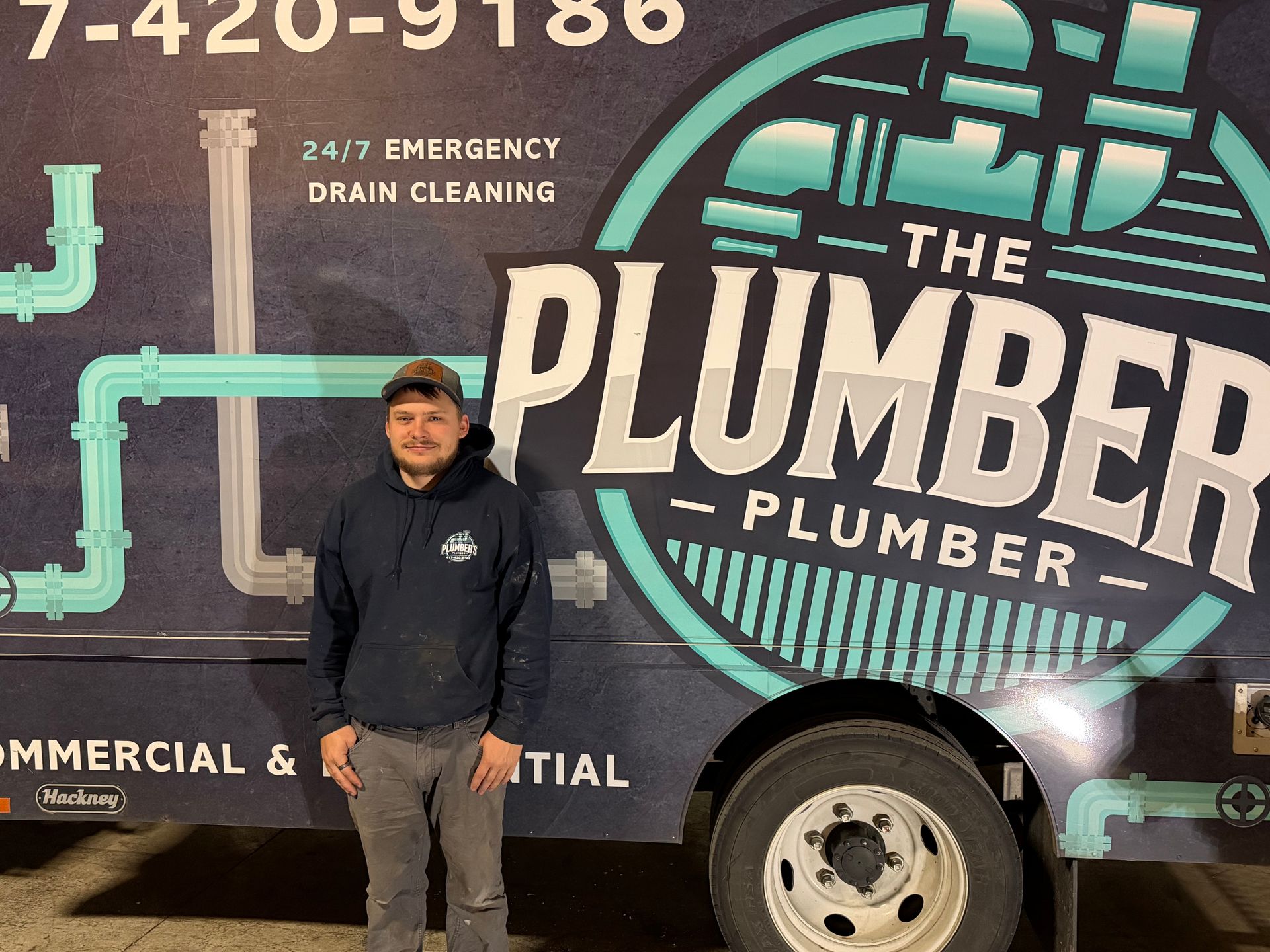 Man in blue hoodie stands in front of a van with 