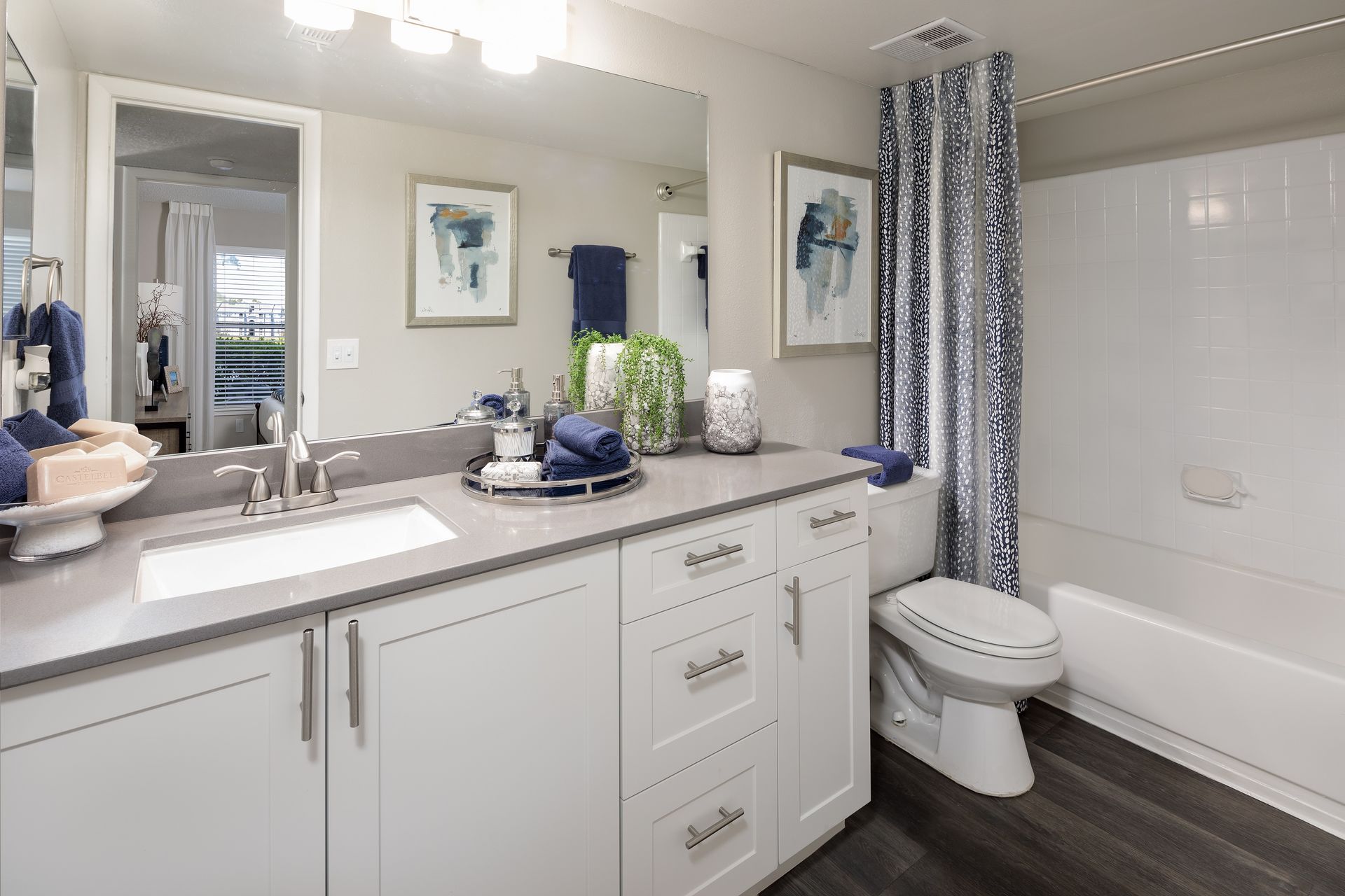 A bathroom with a sink , toilet , bathtub and mirror.