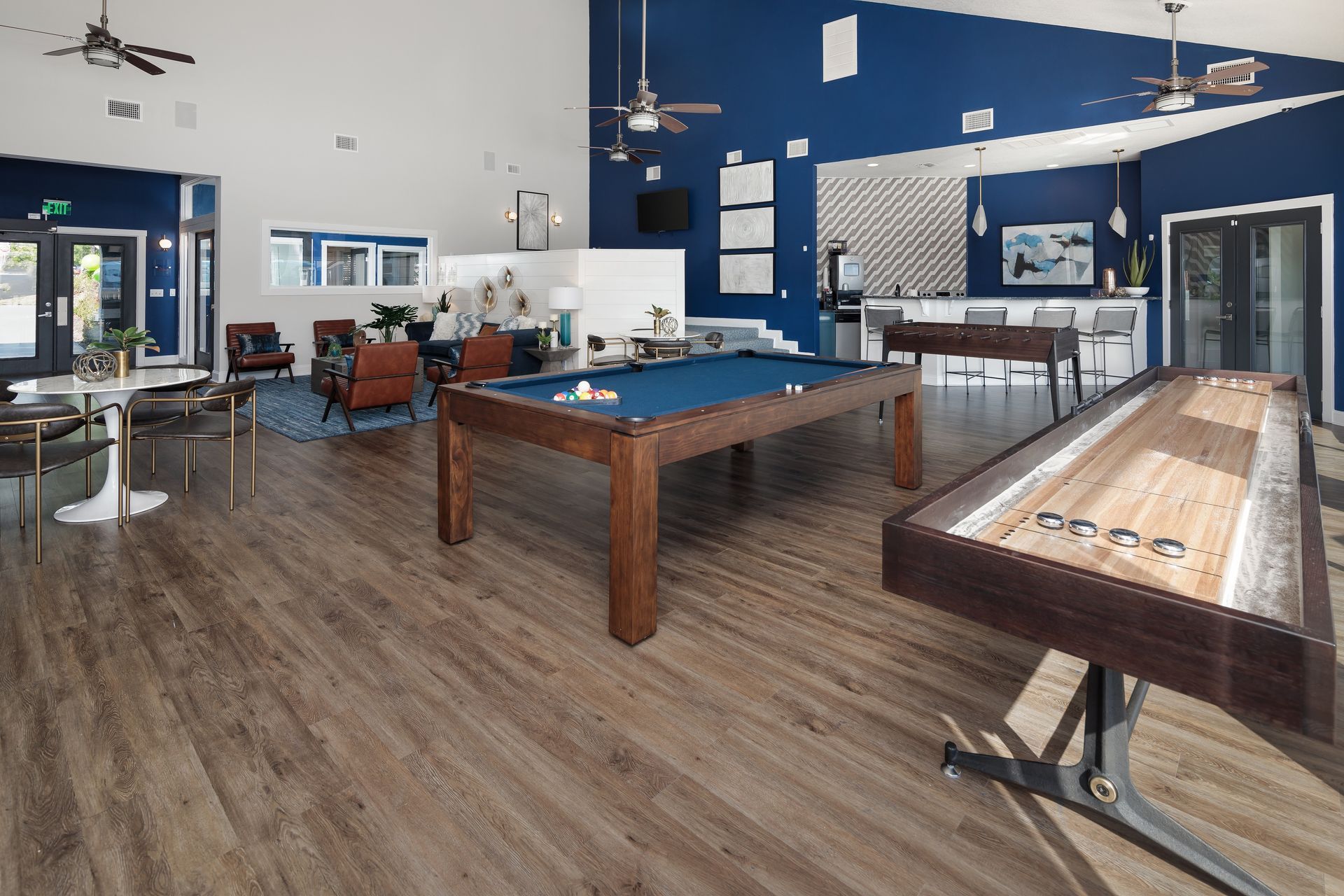 A large room with a pool table and a shuffleboard table