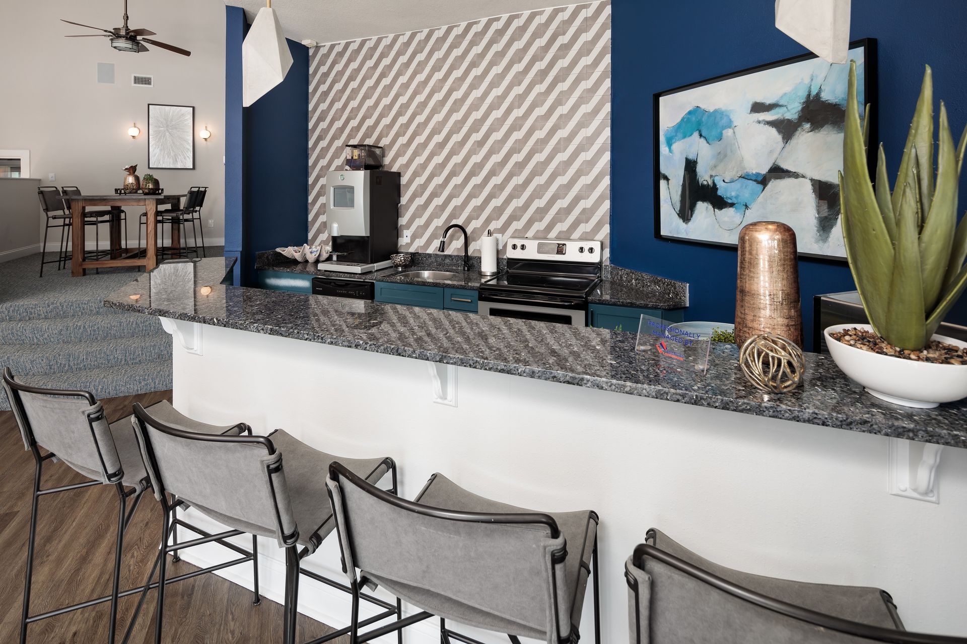 A kitchen with a bar and chairs and a stove