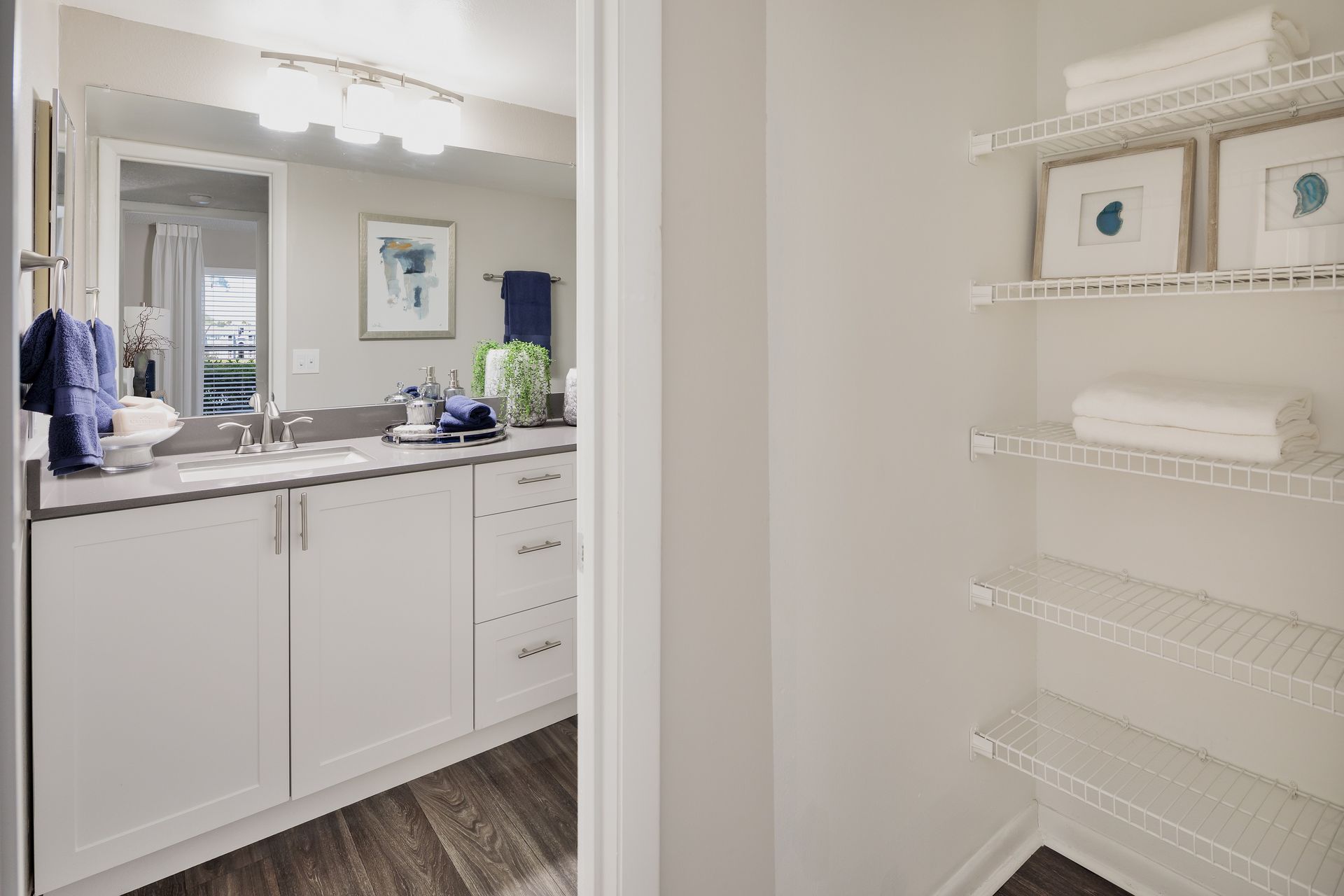 A bathroom with a walk in closet and a sink.