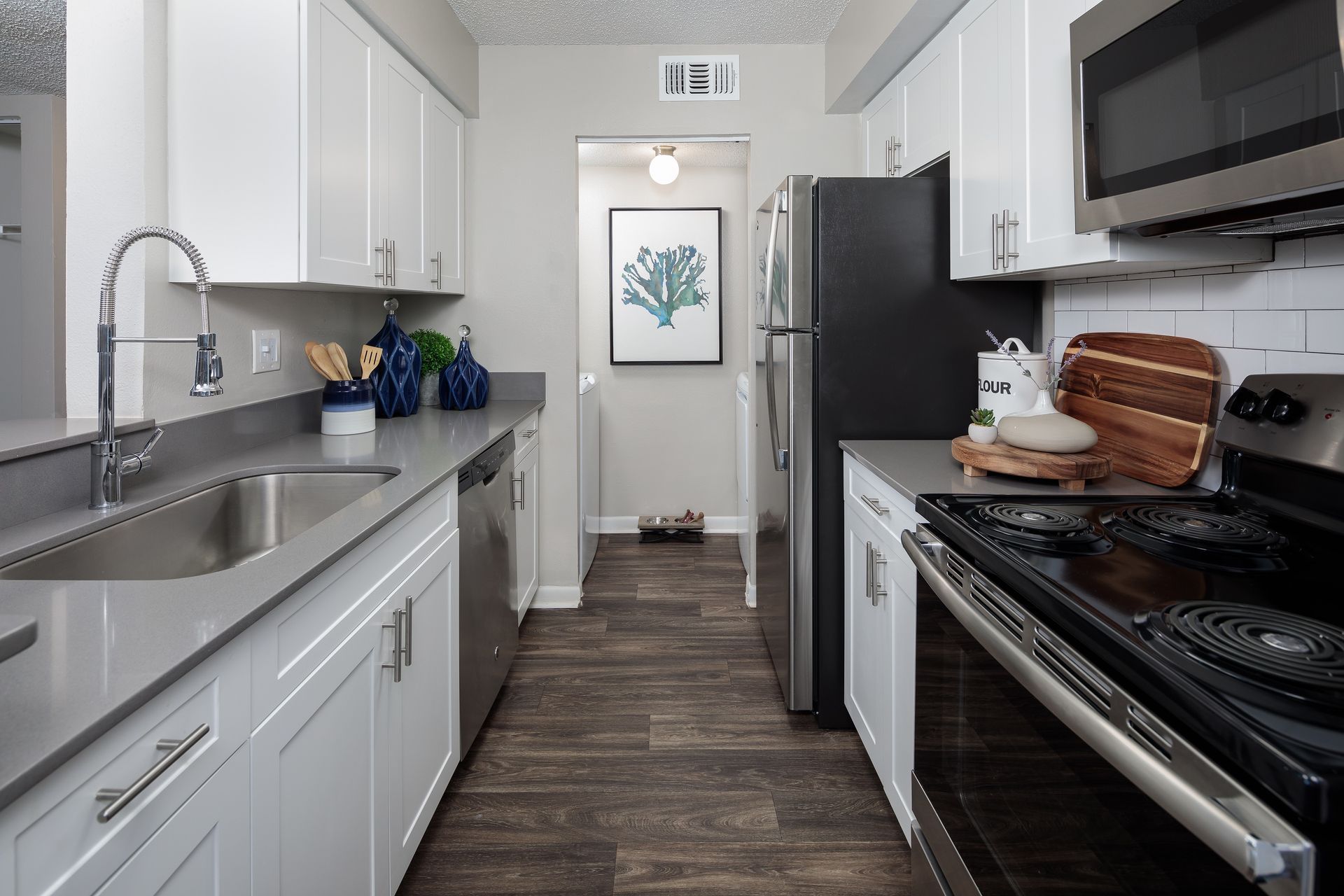 A kitchen with white cabinets and stainless steel appliances