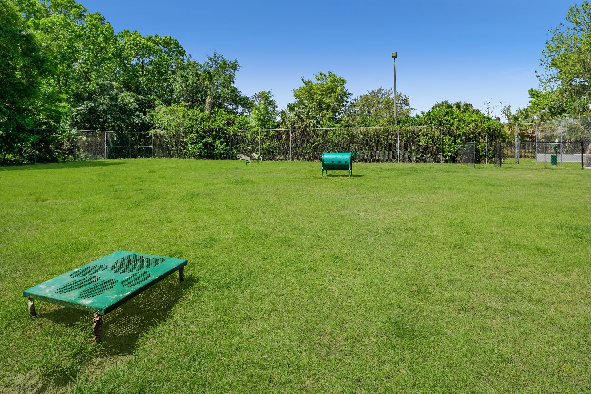 A green table is sitting in the middle of a lush green field.