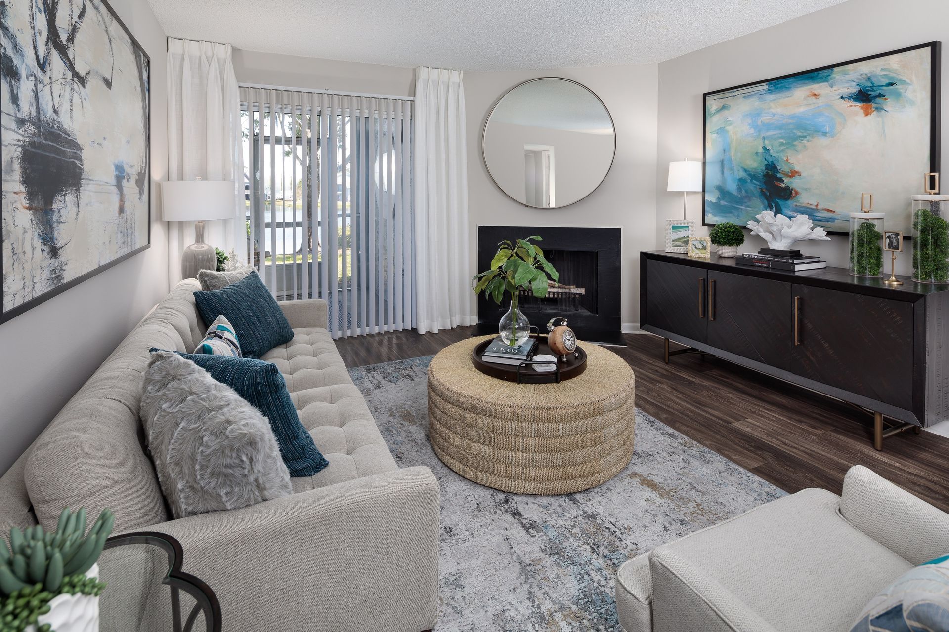 A living room with a couch , chair , coffee table and fireplace.