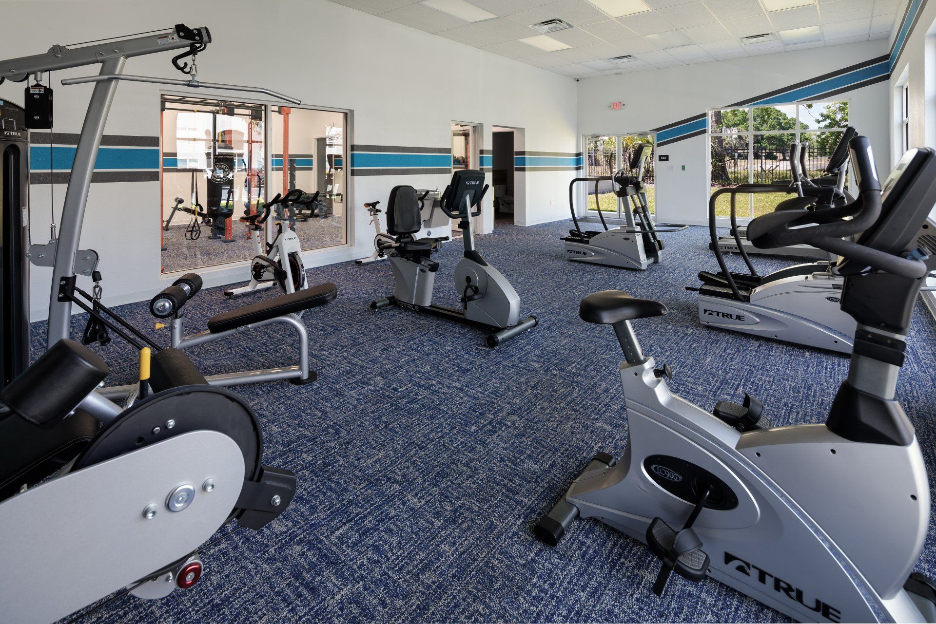 A gym filled with a variety of exercise bikes and treadmills.