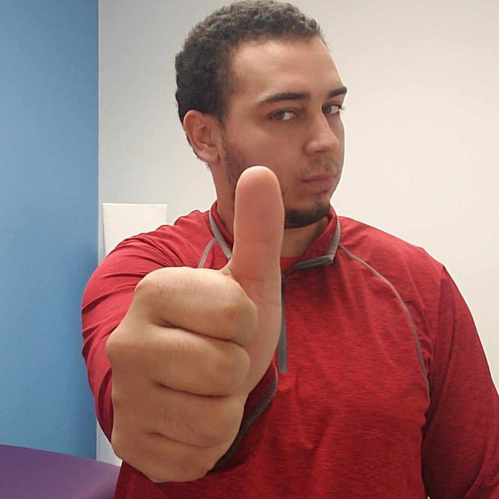 A man in a red shirt is giving a thumbs up sign.