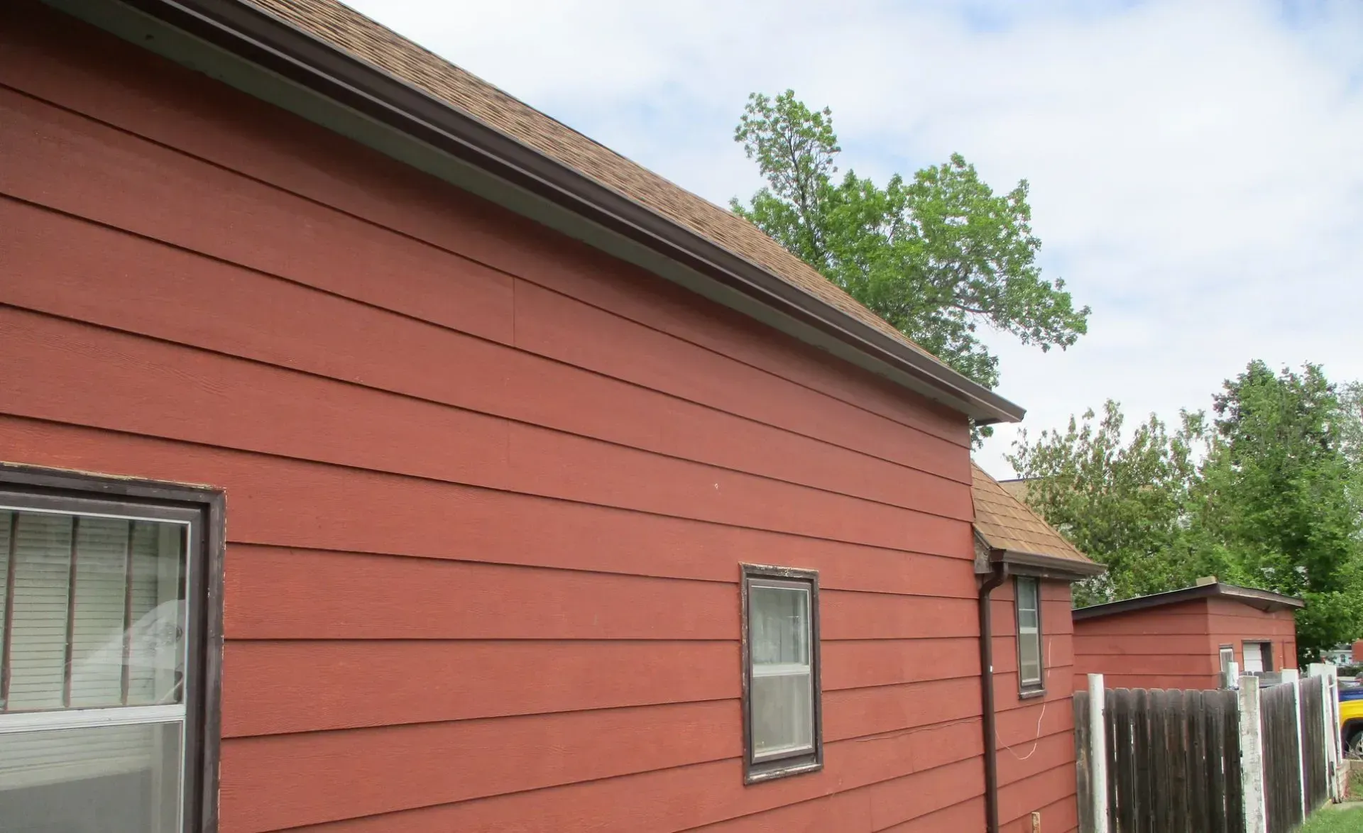 A red house with a wooden fence in front of it