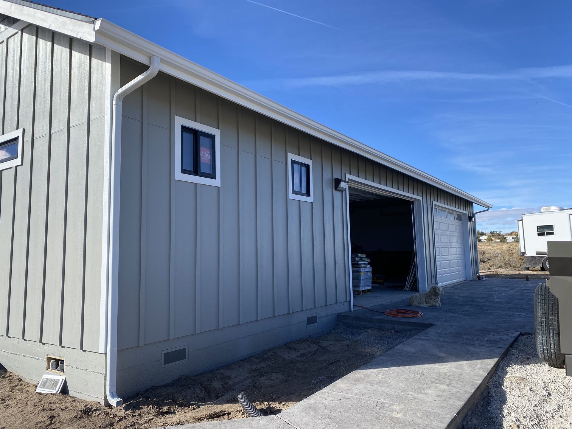 A large gray building with a garage door open.