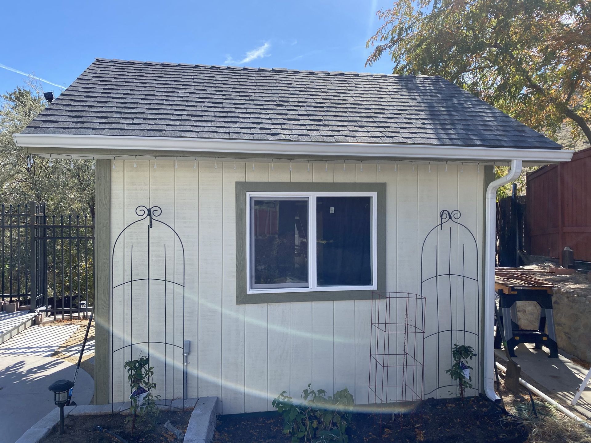 A small white shed with a window and a roof