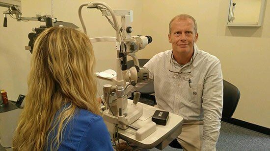 Dr. Tommy Louthan performing a routine eye exam with a femal patient- professional eye care services in Knoxville, TN