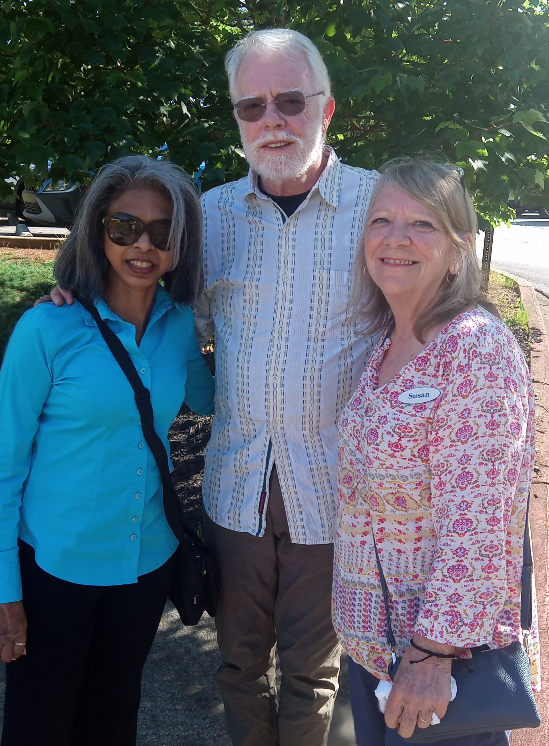A man and two women are posing for a picture