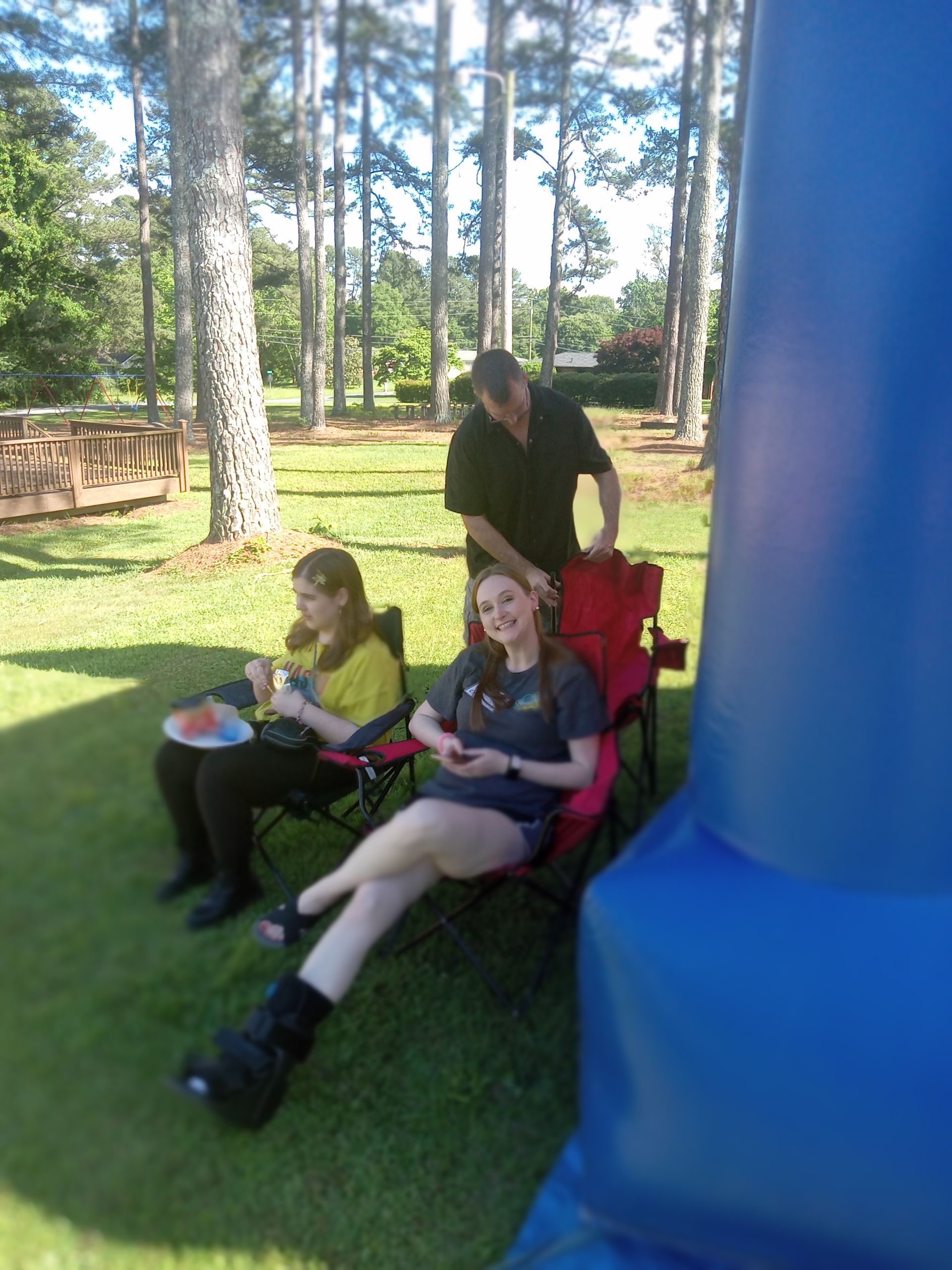 A group of people are sitting on the grass eating watermelon