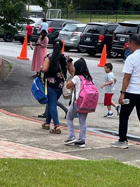 A group of people are walking down a sidewalk.