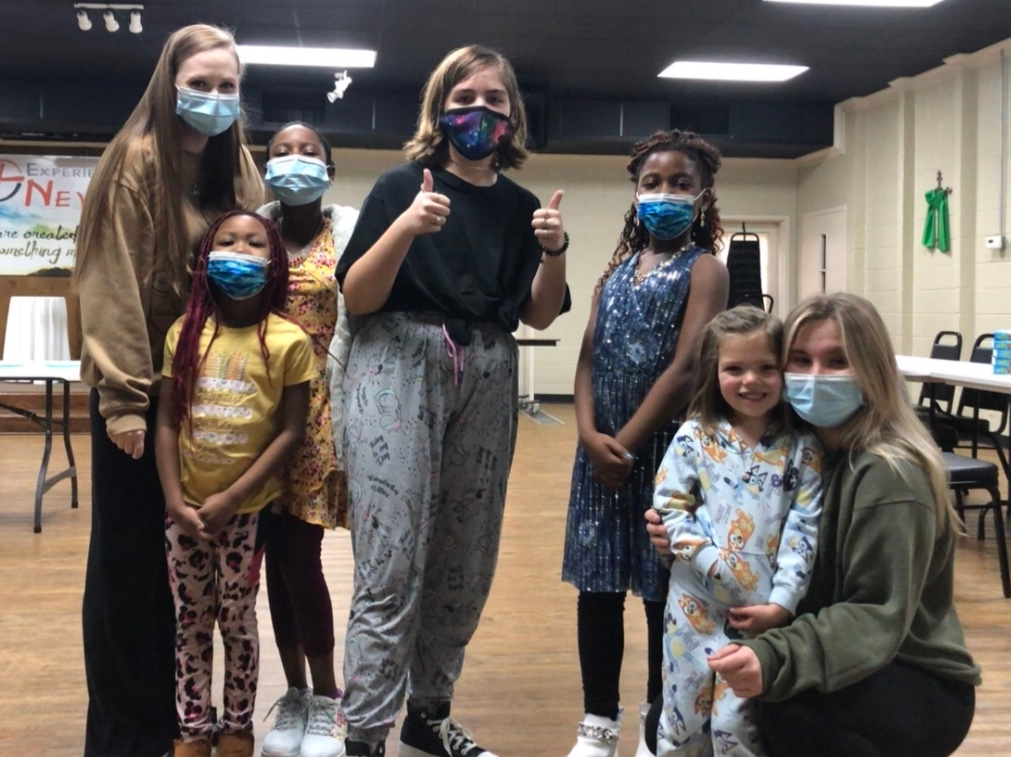 A group of people wearing face masks are posing for a picture.