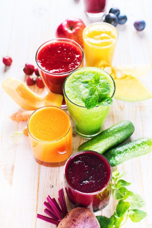 a variety of juices are sitting on a wooden table .
